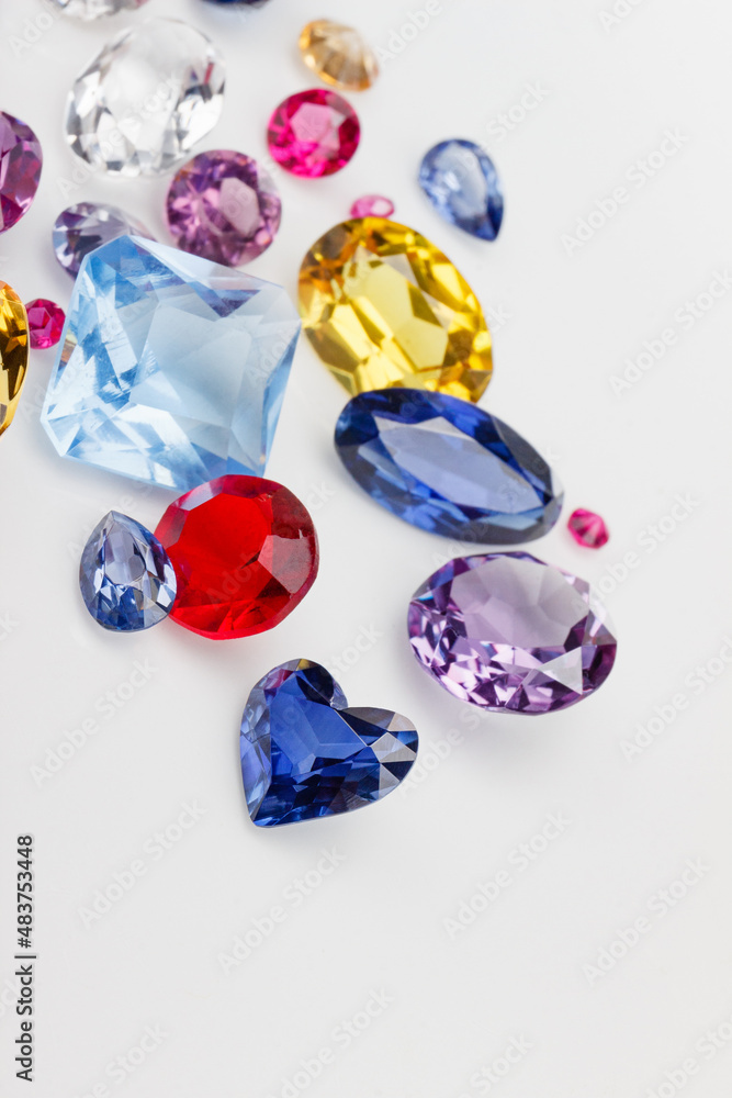 A scattering of precious stones on a light background, close-up. A scattering of precious stones on a light background, close-up.
