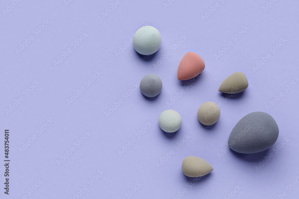 Different makeup sponges on purple background Different makeup sponges on purple background