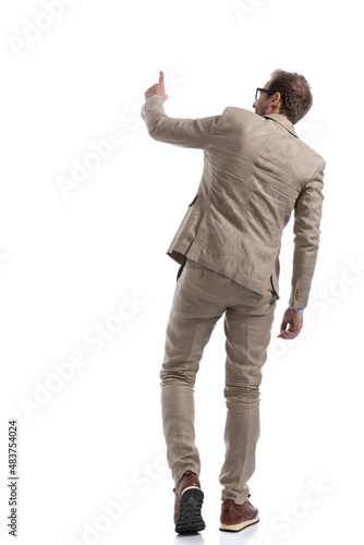 businessman tapping a button, walking and wearing eyeglasses
