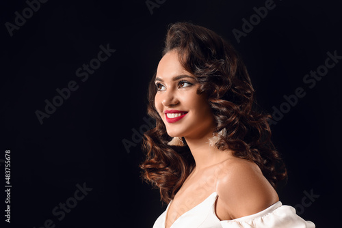 Portrait of smiling woman on dark background