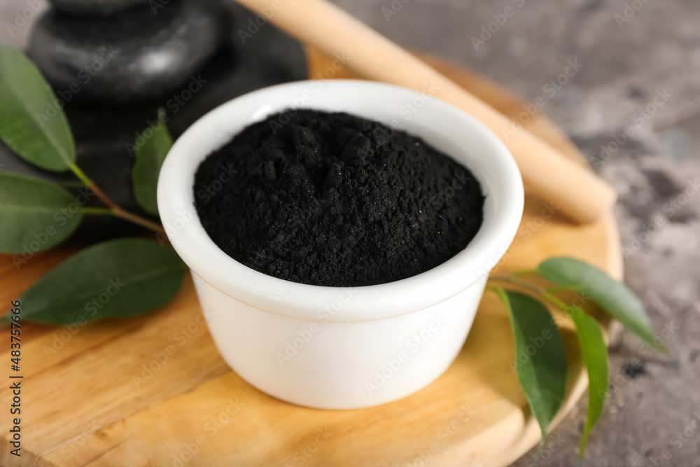 Bowl with activated charcoal tooth powder on table Bowl with activated charcoal tooth powder on table