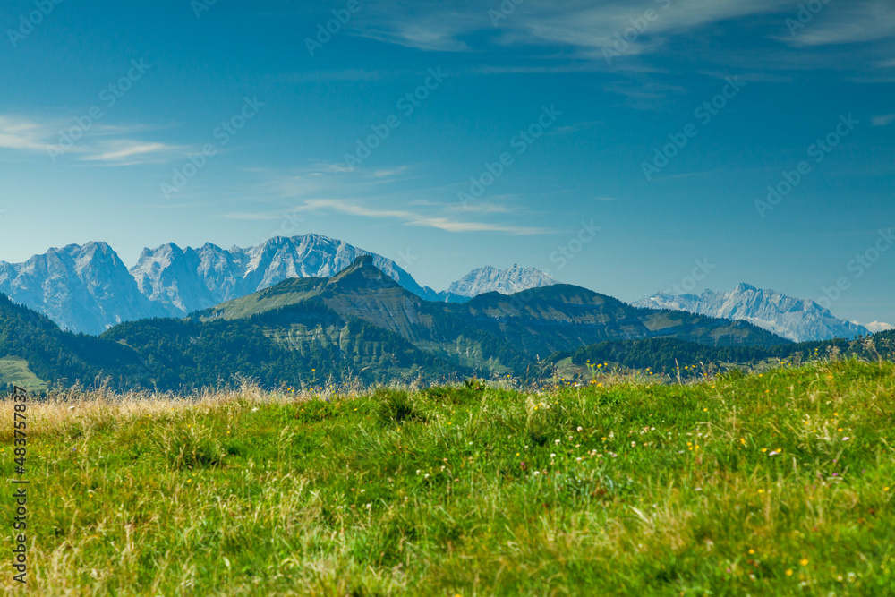 Panorama der Alpen mit Alm und Almwiese vor Gebirge mit Berge und Berggipfel