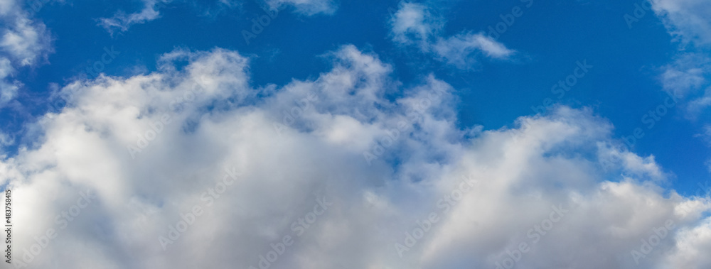 Fototapeta premium Big white fluffy clouds in the blue sky in sunny weather