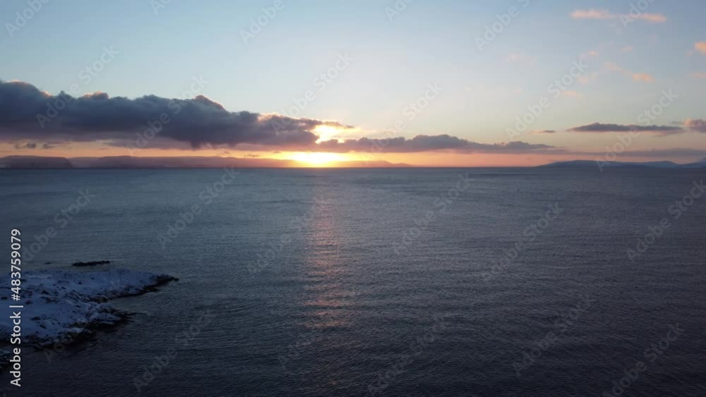 mighty orange first winter sunrise of 2022 behind thin clouds over open arctic seas in northern Norway in northcape county mighty orange first winter sunrise of 2022 behind thin clouds over open arctic seas in northern Norway in northcape county