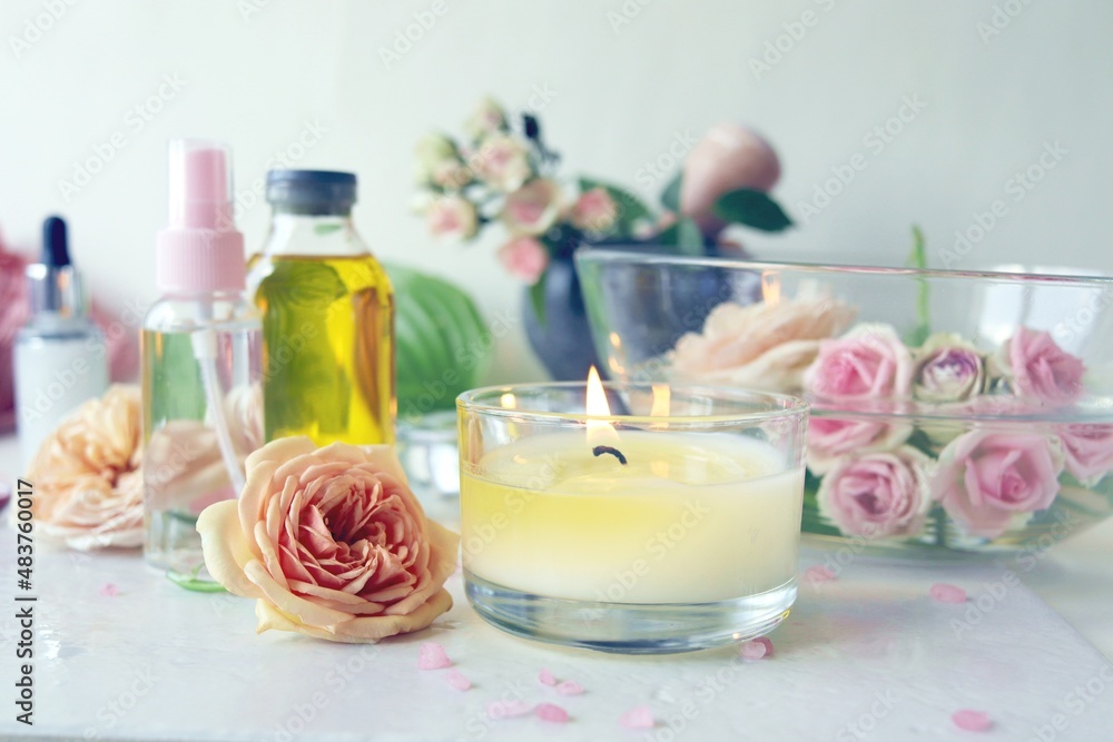 Spa, fresh pink roses, burning candles, oils and tinctures on a light background, healthy lifestyle, relaxation, home cosmetics, aromatherapy, romantic mood, alternative medicine Spa, fresh pink roses, burning candles, oils and tinctures on a light background, healthy lifestyle, relaxation, home cosmetics, aromatherapy, romantic mood, alternative medicine