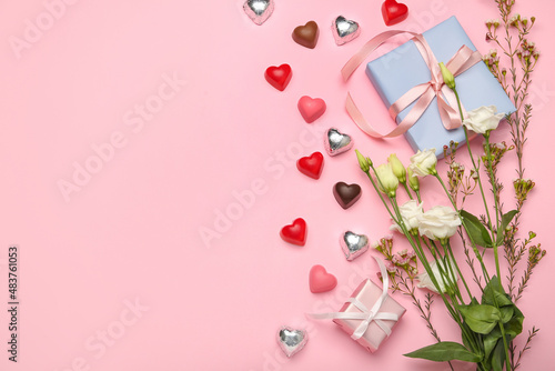 Composition with tasty heart-shaped candies and flowers for Valentine's Day celebration on pink background