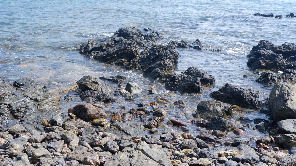 The splashing waves on the black rocks The splashing waves on the black rocks