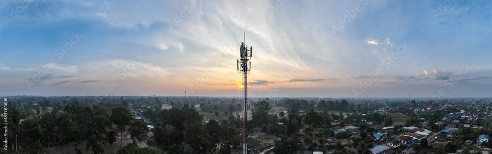 Telecommunication tower of 4G and 5G cellular. Macro Base Station. 5G radio network telecommunication equipment with radio modules and smart antennas mounted on a metal on cloulds sky background.