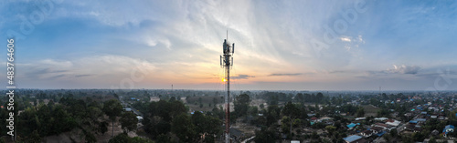 Telecommunication tower of 4G and 5G cellular. Macro Base Station. 5G radio network telecommunication equipment with radio modules and smart antennas mounted on a metal on cloulds sky background.