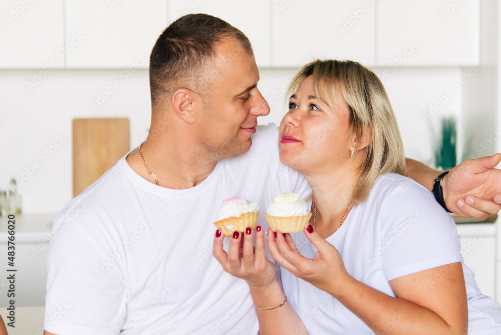 Happy couple having cakes in the kitchen	