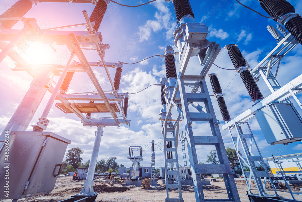 Fototapeta premium Construction of a power transmission substation on a background of blue sky
