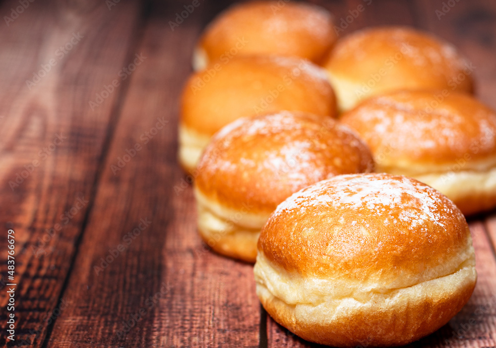 Traditional Tastiness: Cream-Infused Berliner and Krapfen, Europe's Donut Delicacies. On wooden background. Selective focus