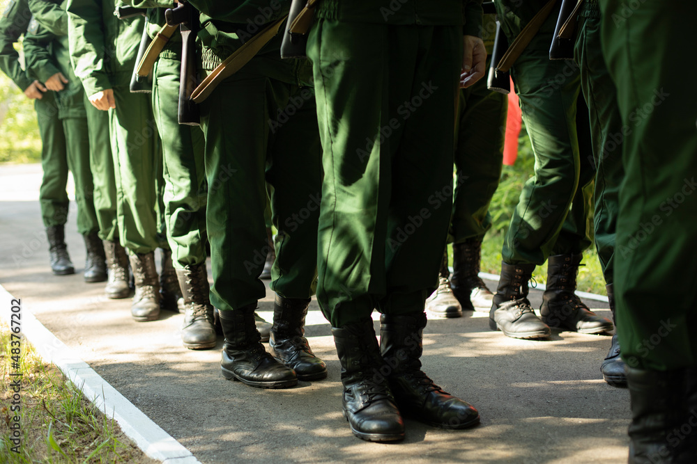 Military stands in row. Soldiers' shoes. Boots and military uniforms.
