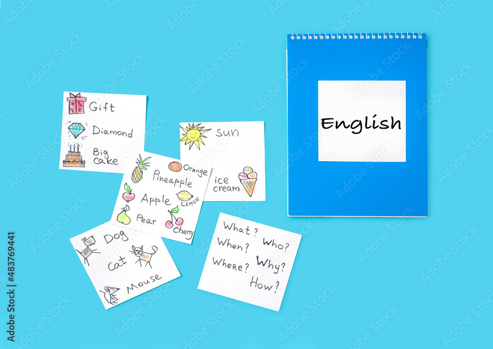 Notepad and cards with words on a blue background. We learn English. Notepad and cards with words on a blue background. We learn English.