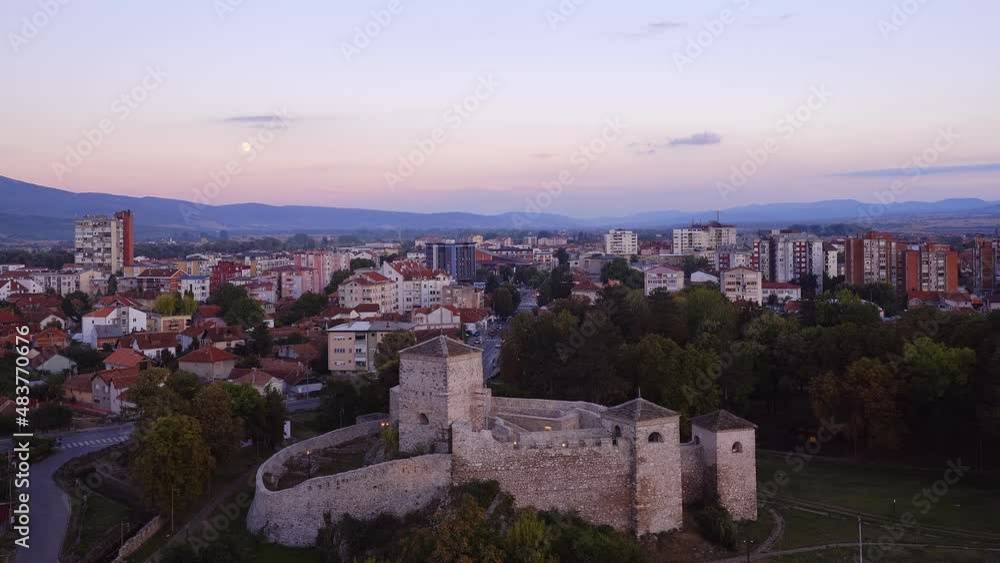 Time-lapse of Pirot with foreground fortress and cityscape in the background during blue hour Time-lapse of Pirot with foreground fortress and cityscape in the background during blue hour