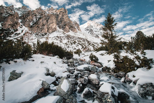 Wallpaper Mural River (stream) flowing in mountains with big snowy and frozen rocks. Beautiful and amazing snowy scery of mountains with blue cloudy sky. Torontodigital.ca