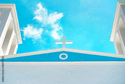 Church cross on top of roof on blue sky background