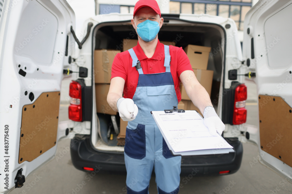The delivery man holds out documents for signature The delivery man holds out documents for signature