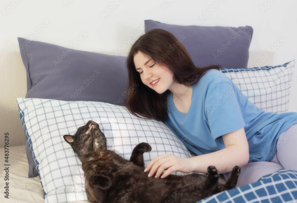 happy teen girl with black cat in white bedroom happy teen girl with black cat in white bedroom
