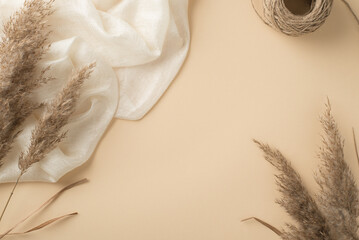 Top view photo of white light scarf spool of twine and reed flowers on isolated beige background with copyspace