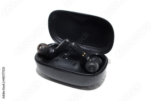 black wireless in-ear headphones in a case. isolation on white.