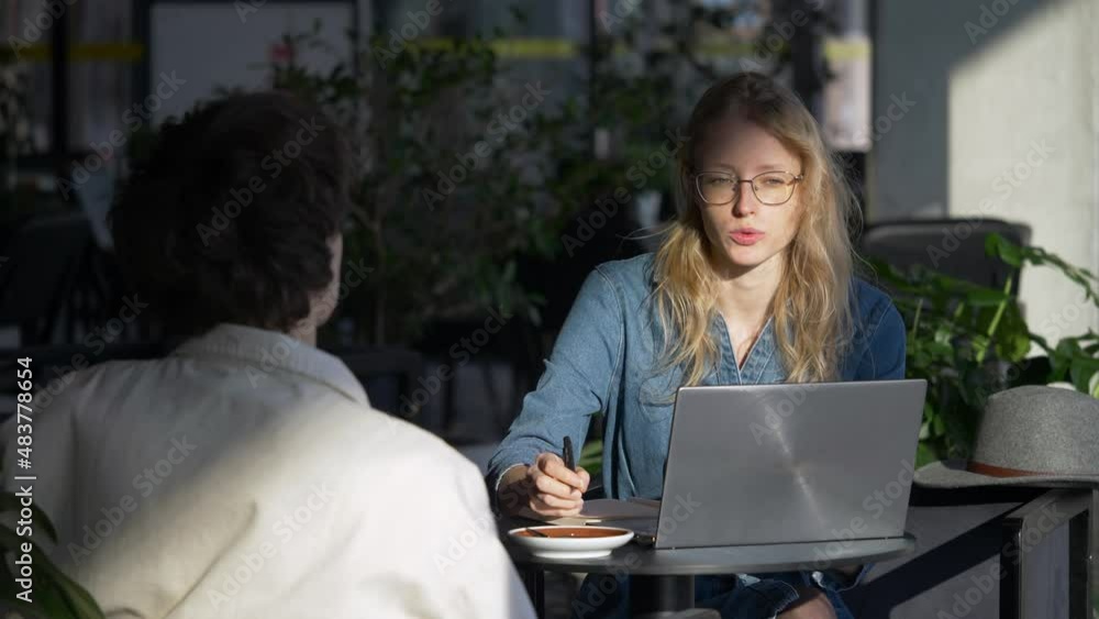 Slow motion camera shot of young woman first time meeting candidate for job. Female starts to laugh after her interlocutor makes a joke. Beautiful, blond hair woman. Job interview. Slow motion camera shot of young woman first time meeting candidate for job. Female starts to laugh after her interlocutor makes a joke. Beautiful, blond hair woman. Job interview.