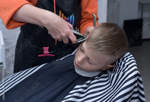 The child gets a haircut in the salon