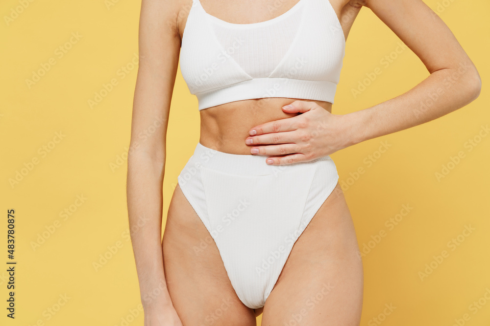 Cropped close up photo shot slim skinny attractive young caucasian woman 20s wear white underwear with perfect fit body point index finger on waist belly isolated on plain yellow background studio Cropped close up photo shot slim skinny attractive young caucasian woman 20s wear white underwear with perfect fit body point index finger on waist belly isolated on plain yellow background studio