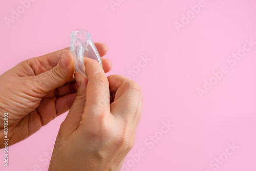 Closeup image of woman hands showing how to fold silicone menstrual cup