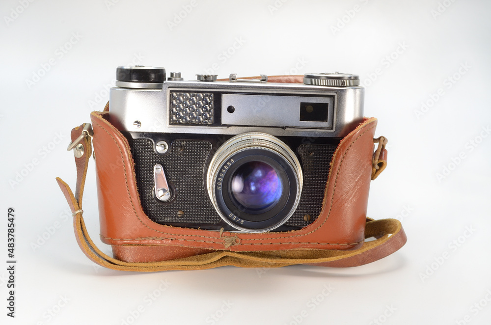 Old film camera in a leather case on a white background.