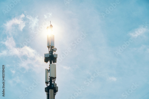 Telecommunication tower of 4G and 5G cellular. Macro base station. LTE radio network communication equipment with wireless modules and smart antennas mounted on metal on clouds sky background.