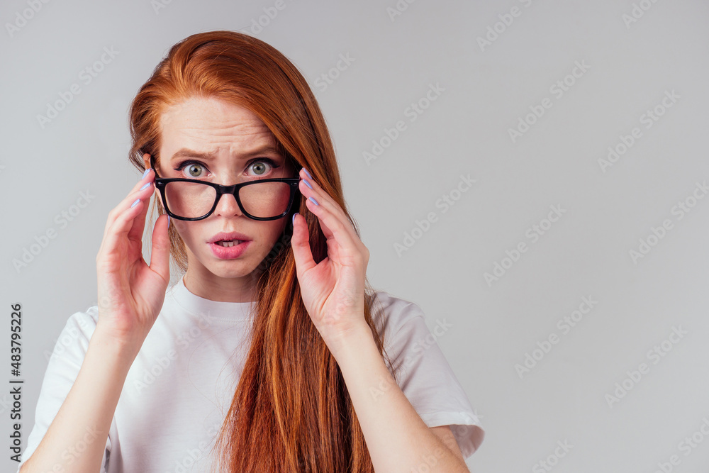 redhaired ginger woman wearing glasses and white cotton eco t-shirt in gray studio background redhaired ginger woman wearing glasses and white cotton eco t-shirt in gray studio background