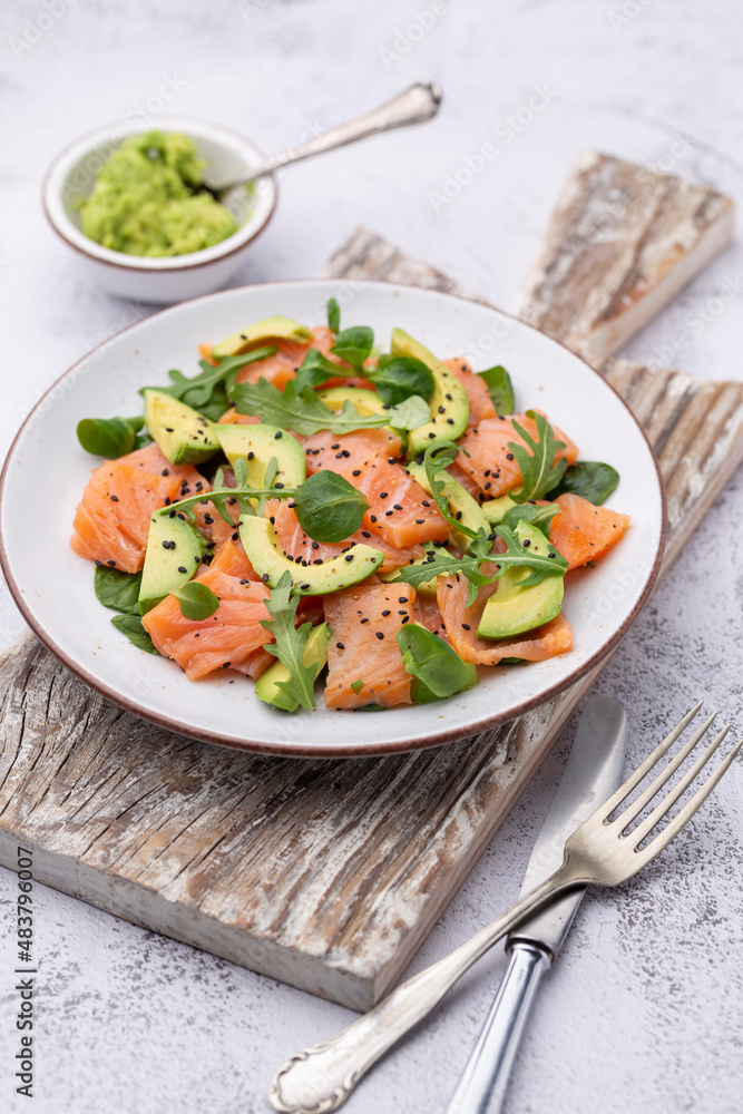Fresh salmon salad with avocado, for keto and low carb diet. Rusty background, top view, copy space. Fresh salmon salad with avocado, for keto and low carb diet. Rusty background, top view, copy space.