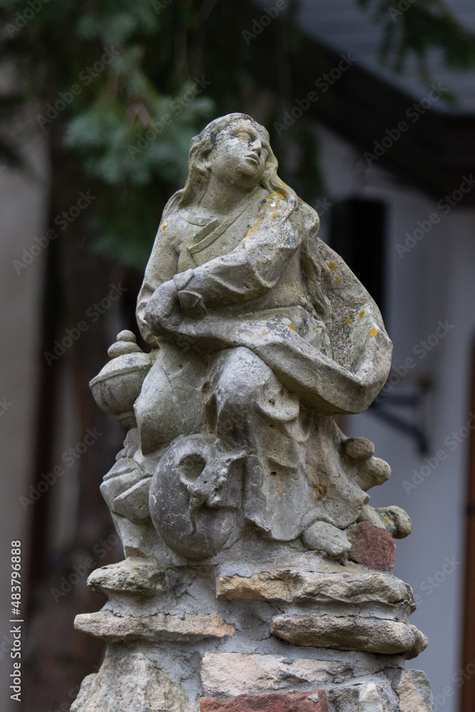 Obraz premium Ancient sculpture of a Catholic saint with a skull underfoot in the yard of Church of the Blessed Virgin Mary, Mother of Consolation in Wroclaw