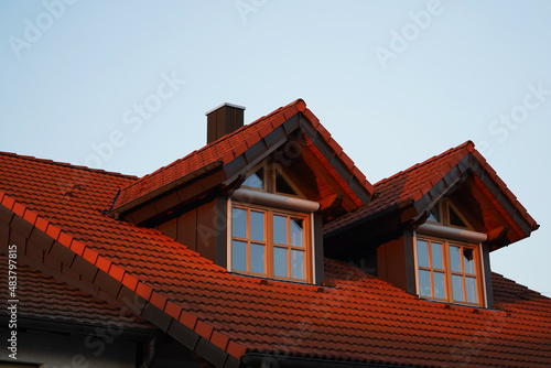 High dormer windows with lattice windows on a residential building in the evening light