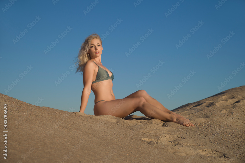 sports woman in a swimsuit on the sand