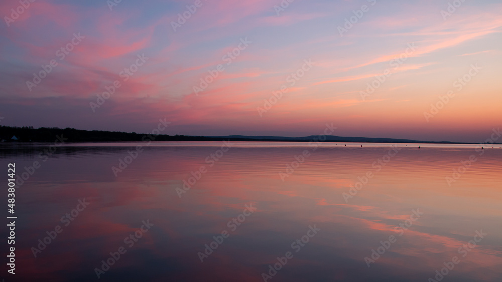 shortly after sunset at the Steinhuder Meer. The sky colored red. reflection on the water surface. Works well as a sky and as a texture