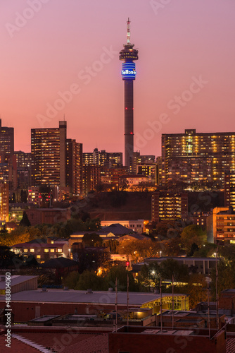 A vertical cityscape taken after sunset with a pink sky,, of the central business district of the city of Johannesburg, South Africa