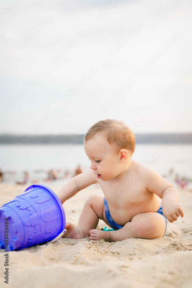 portrait of baby sitting on the seashore and playing in the sand, children's day concept, summer time portrait of baby sitting on the seashore and playing in the sand, children's day concept, summer time