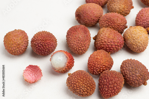 Lychees are scattered on table.