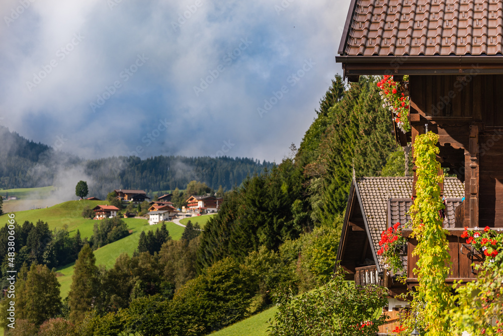 View of green meadow in mountains from typical wooden house balcony  village  on Alps, Austria.
