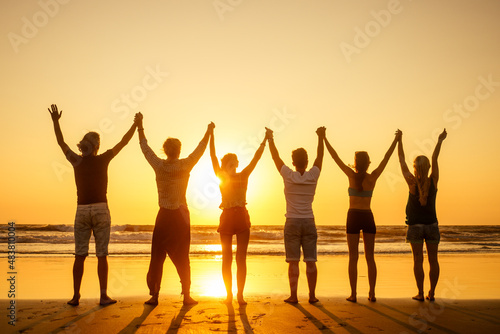 six health people in stand hatha position with hand up raced and breath full chest in Goa India beach at sunset