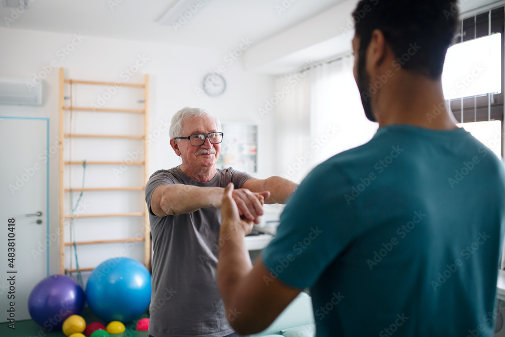 Young physiotherapist exercising with senior patient in a physic room Young physiotherapist exercising with senior patient in a physic room