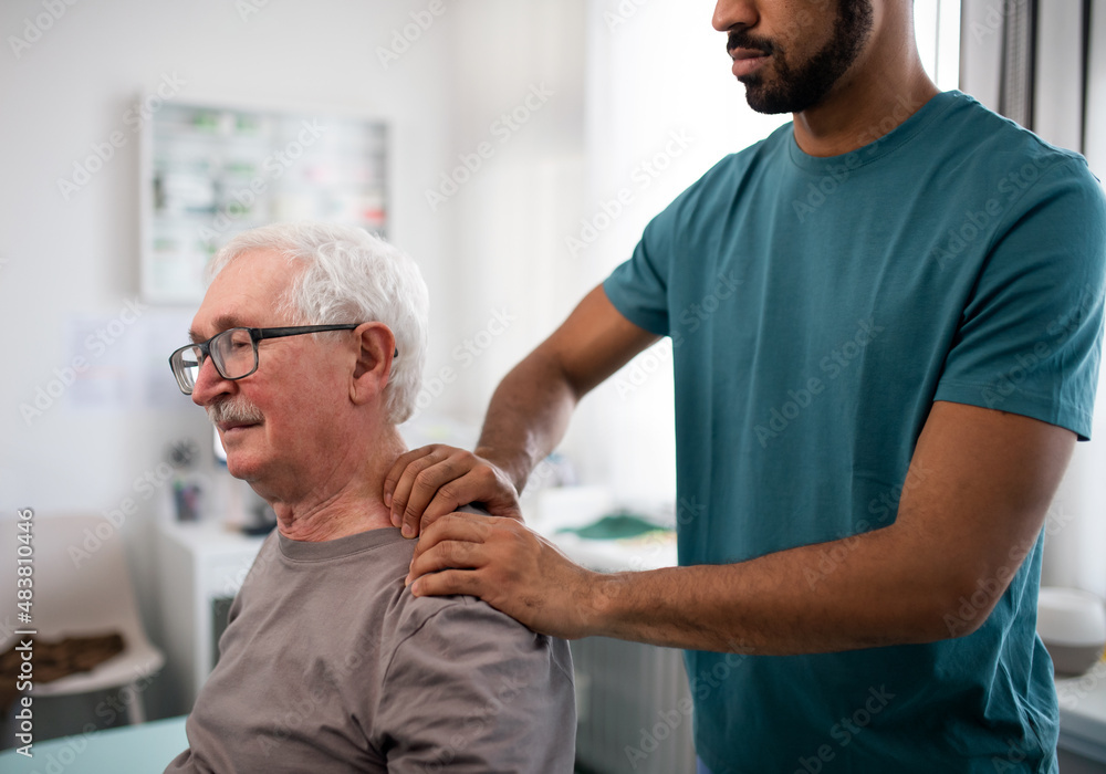 Young physiotherapist massaging the neck of senior patient in a physic room Young physiotherapist massaging the neck of senior patient in a physic room