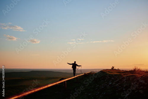 photo of a guy walking through a pipe in backlight at sunset