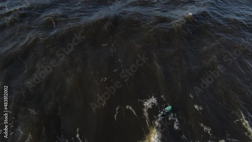 Winter surf in Baltic sea. Surfer paddling and crushing in waves. Drone video. How to surf in Europe. Surfer in winter hydra in Riga, Latvia