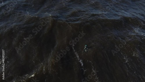 Winter surf in Baltic sea. Surfer paddling and crushing in waves. Drone video. How to surf in Europe. Surfer in winter hydra in Riga, Latvia