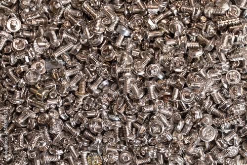 Numerous small silver mounting screws. Bolts are available in various sizes and shapes. Background. Texture.