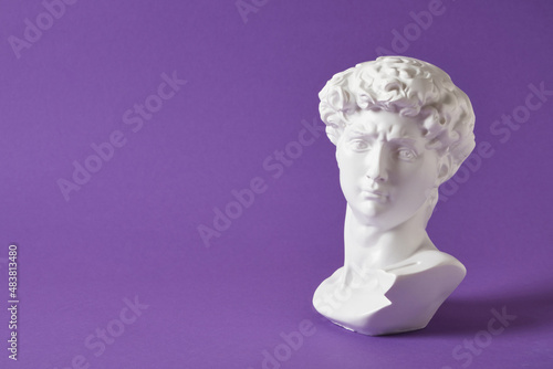 bust of david replica on purple background copy space