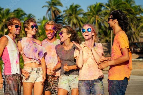 mixed race friends having fun with colors on seaside outdoors in Goa India © yurakrasil